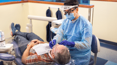 Patient receiving dental cleaning from a student student.