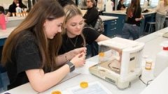 two high school students looking at pills