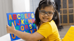 little girl with alphabet board