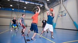 Students playing basketball inside gym