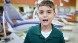 Child smiling in dentist office.