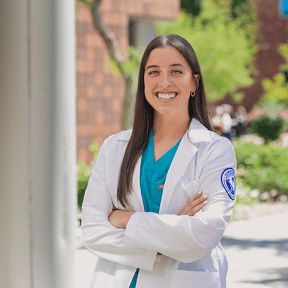 Student posing in white coat