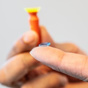 finger holding a contact lens