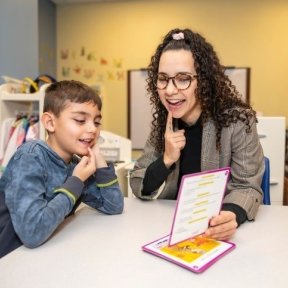 Child reading with clinician