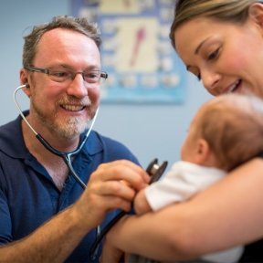 Doctor with baby and mother.