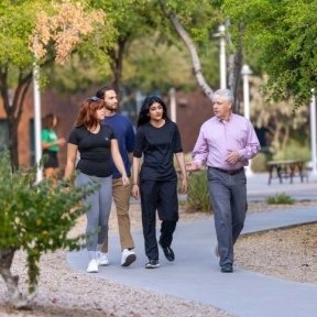 Group of 4 people walk outside at the Midwestern University Glendale campus.