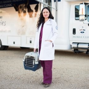 Dr. Rachael Kreisler standing in lab coat in front of mobile clinic.