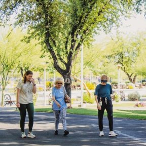 Patients walking outdoors with a healthcare provider.