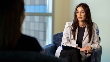 Psychologist sitting in an armchair and listening to a patient