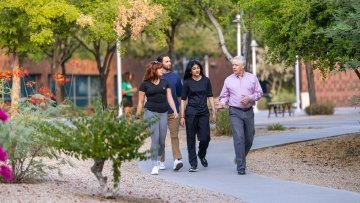 Three students wanting with a professor discussing Public Health.