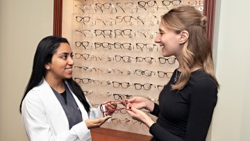 MWU Optician shows frames to a customer.