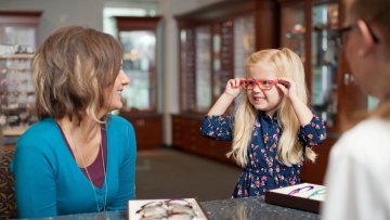 Young child tries on glasses at the MWU Eye Institute.