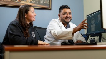 MWU Clinics dentist discusses dental exam results with patient.