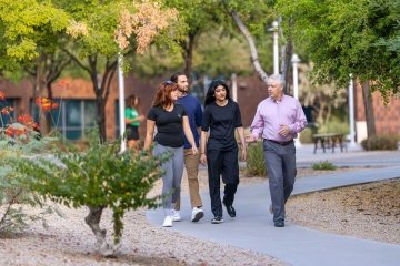 Three students wanting with a professor discussing Public Health.