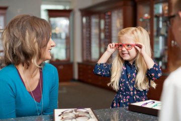 Young child tries on glasses at the MWU Eye Institute.