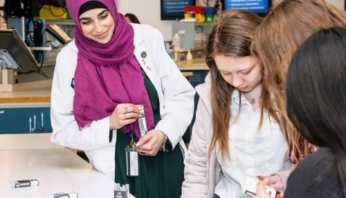 trainer with high school students in lab