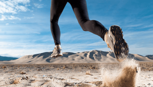 Woman running through a desert.