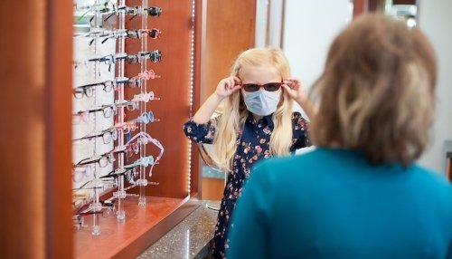 Young girl tries on sunglasses.