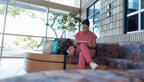 student reading, wearing scrubs