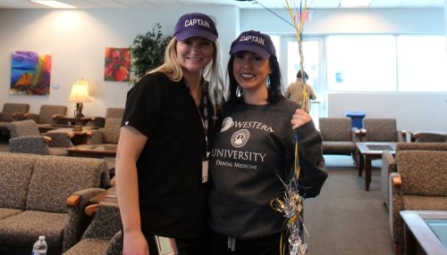 Two students from the College of Dental Medicine-Arizona pose with blue and yellow balloons.