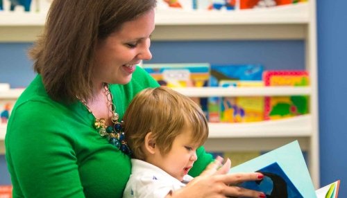 Mom reading to her child as he sits in her lap