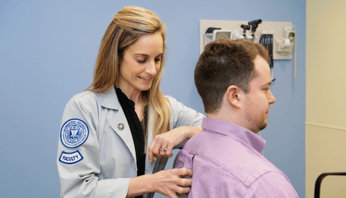 doctor examining patient, checking his back