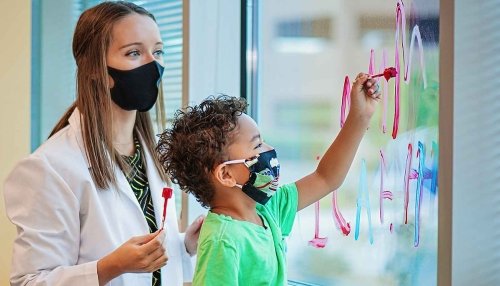 Doctor with child patient painting to help with sensory issues.