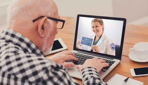 Patient meeting with doctor on his laptop at a wooden table
