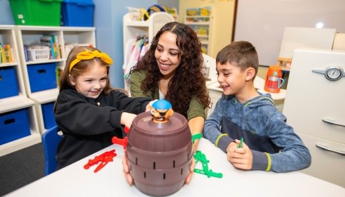 Two children play a game with speech-language pathologist at the MWU Downers Grove Clinic.