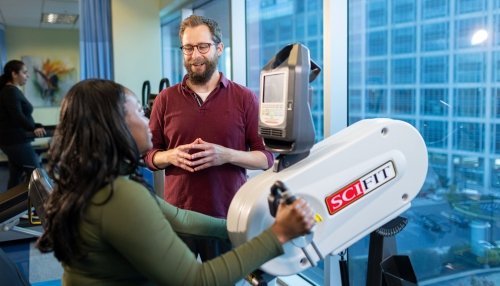 Physical therapist helping patient with mobility exercise.