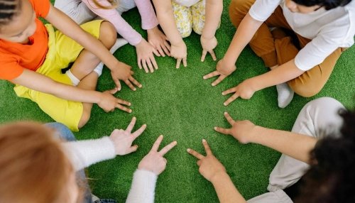 children in a circle touching grass