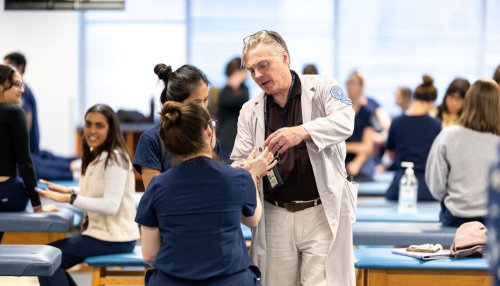 Faculty helping students in OMM lab