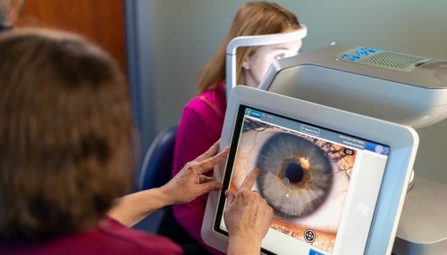 Optometrist views close up image of eye.