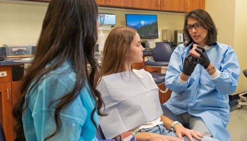 Dentist and dental student speaking to patient