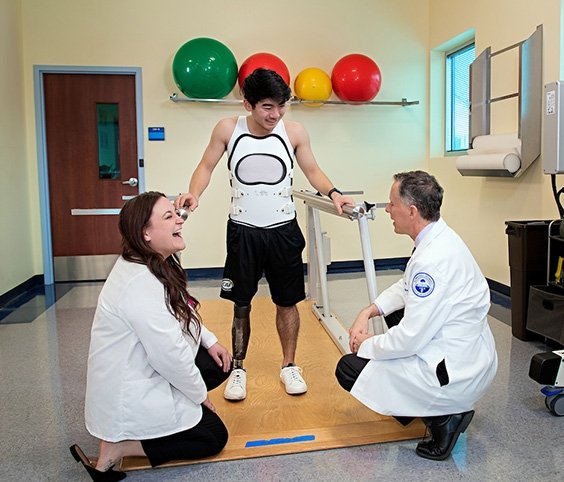 Therapy Institute helping a young man practice walking with new inhancements