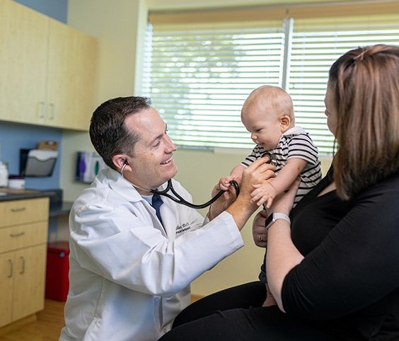 Baby getting his heartbeat checked by a doctor