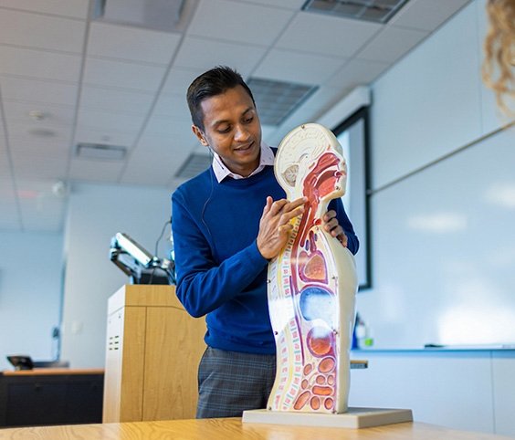 Speech Language Pathology professor explaining question with human model.